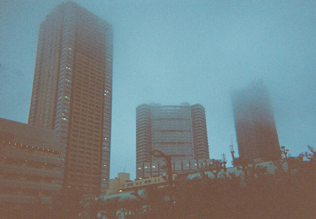 雨雲に覆われる池袋のビルディング